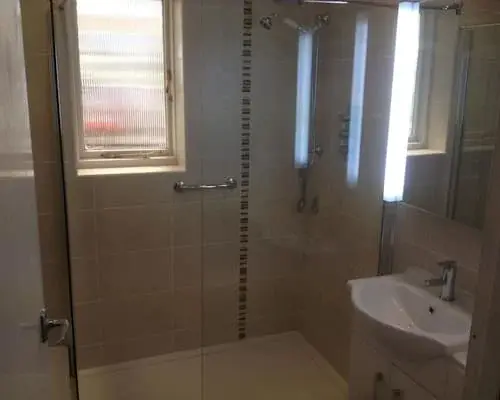 Completed tiled bathroom with shower and basin