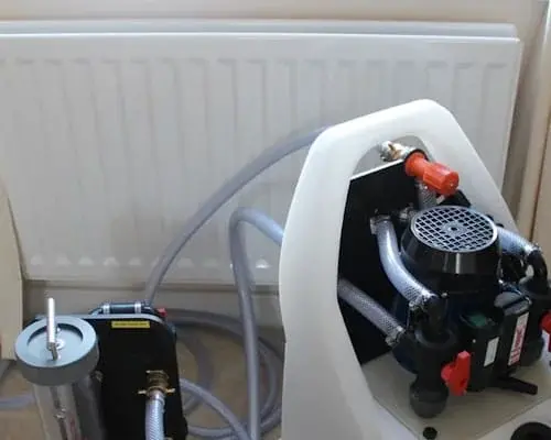 Power flushing equipment connected beside a radiator