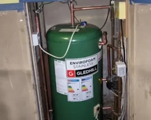 Hot water cylinder with connected pipework